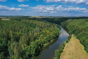 Pohled z ptačí perspektivy na lokalitu Zábělá – po pravé straně a na Háj – na levé straně. Uprostřed směrem do pozadí snímku prochází Berounka.