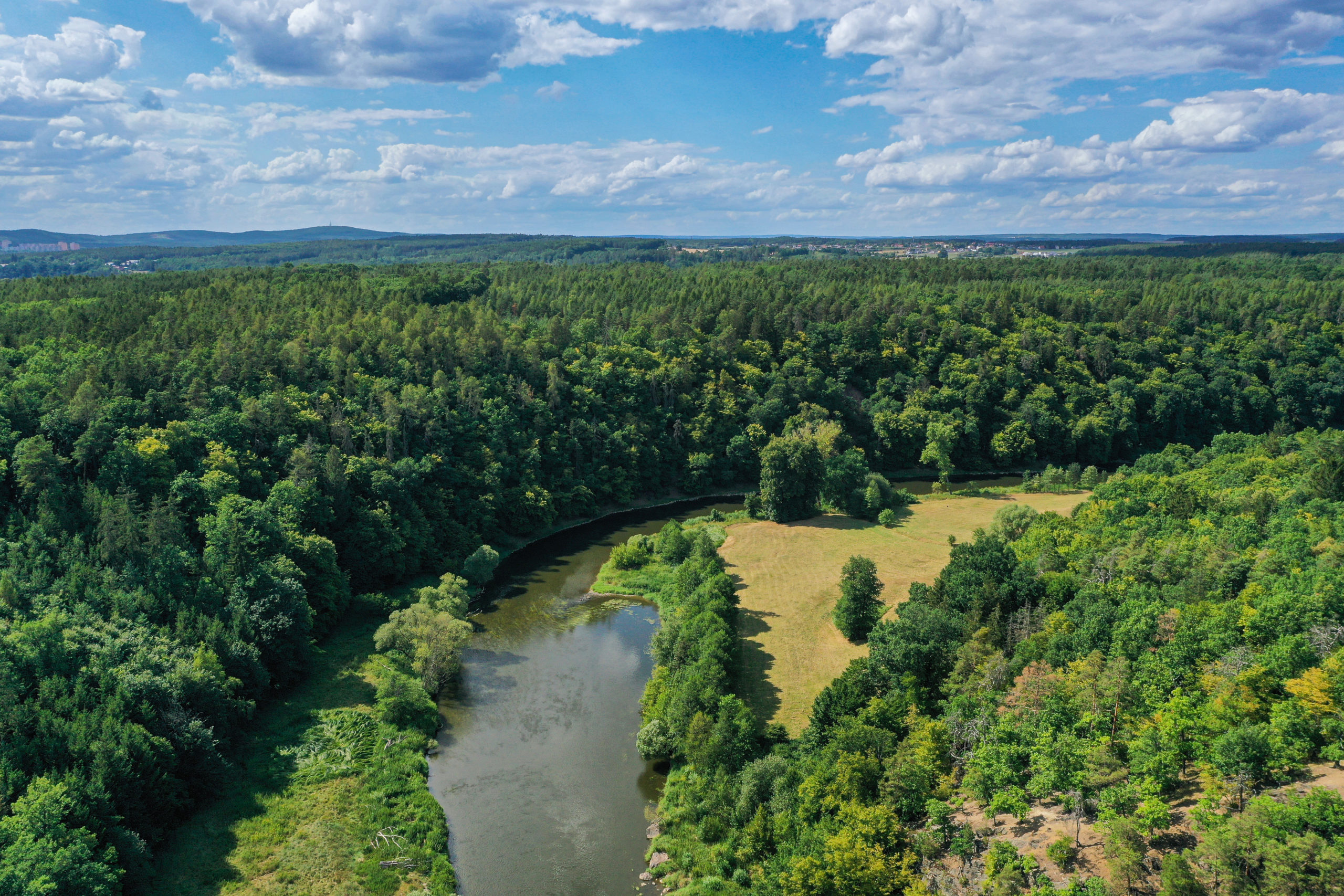 <h1>Háj a Zábělá</h1><br />
Pohled na lokalitu Háj z ptačí perspektivy. Lesnatý pás prochází podél ohybu koryta řeky od levé k pravé straně snímku. V popředí vlevo dole Zábělá – svah smíšeného lesa. Ve střední části řeka Berounka.